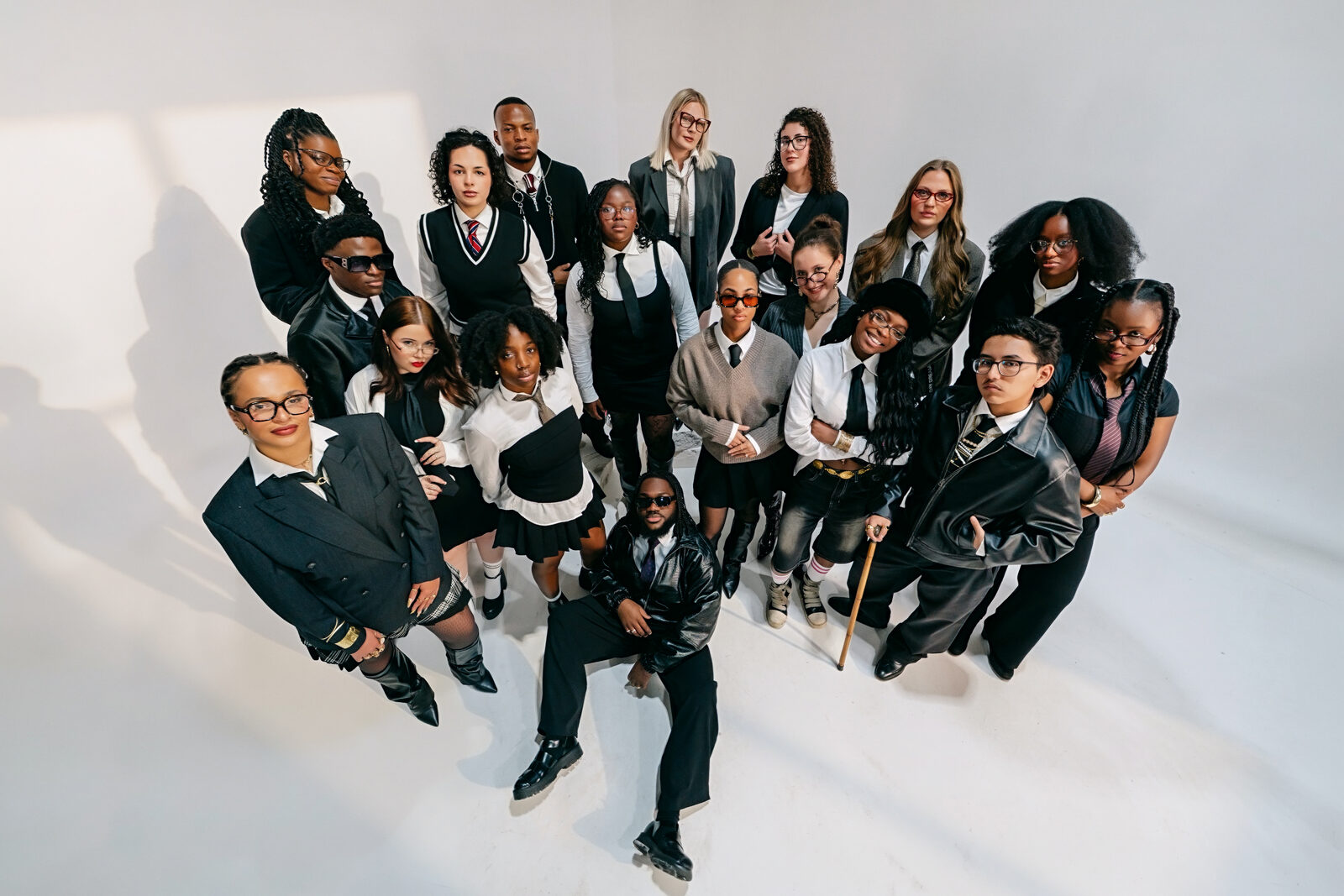 A stylised group portrait of the Jabadams collective posing in coordinated black-and-white outfits against a white studio backdrop.